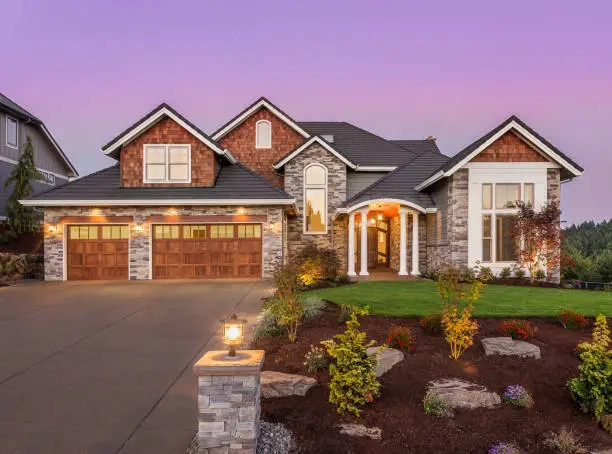 The front view of a two-story, transitional home with a garden in front.