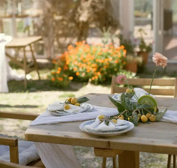 And outdoor placement setting on a wooden table on a warm day.