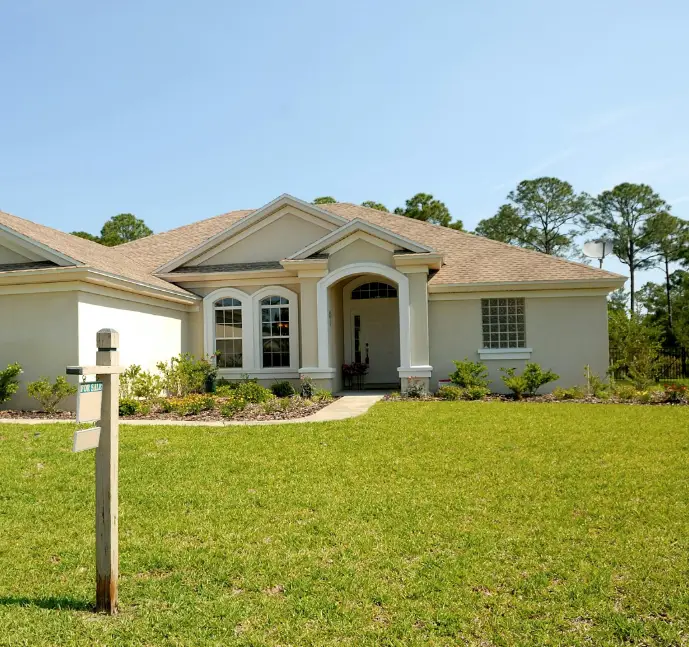 A one-story home with a for sale sign in the yard.