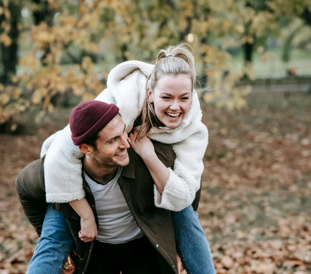 A happy couple, where a man carries his girlfriend on his back.