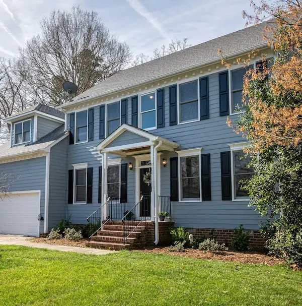 A colonial home with blue siding and a garage.