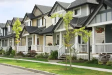 A row of townhouses with a sidewalk and a road out front.