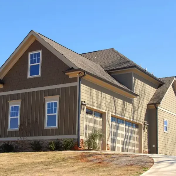 A large house on top of a hill with a three-car garage.