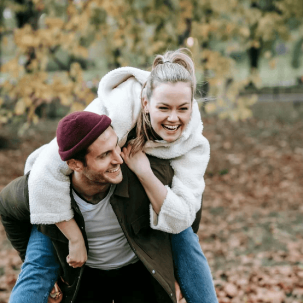 A happy couple, where a man carries his girlfriend on his back.