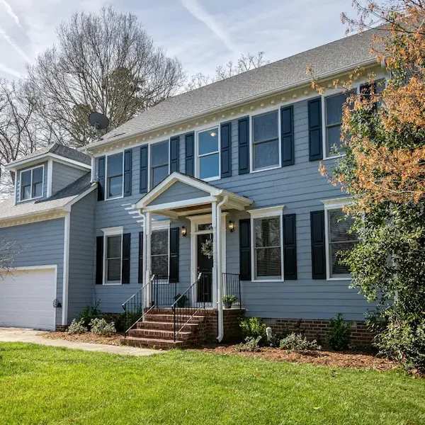 A colonial home with blue siding and a garage.